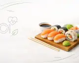 Czy sushi jest zdrowe? Na talerzu nigiri z łososiem, rolki maki z ogórkiem i awokado, sos sojowy, wasabi i imbir. Obok ikony serca z pulsem i liścia.
