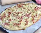 Flammekueche croustillante, garnie d'oignons et lardons. La vraie recette flammekueche, prête à être dégustée.