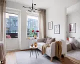 Ett mysigt vardagsrum med soffa, stort klaffbord och utsikt mot en balkong.