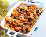 Pyszna zapiekanka z mięsem mielonym, makaronem rigatoni, oliwkami i pomidorami, posypana serem i szczypiorkiem.
