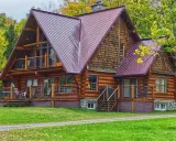 Chalet en bois rond avec toiture métallique, entouré d'arbres aux couleurs d'automne. Un exemple de développement durable bâtiment, alliant esthétique et respect de l'environnement.