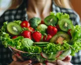 Miseczka pełna świeżych owoców i warzyw, jak kiwi, truskawki, pomidorki, sałata. Czy to zdrowa dieta, czy już ortoreksja?