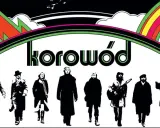 Grupa ludzi w czerni, jakby z dwóch morgi słońca, idzie pod tęczą. Napis "korowód" sugeruje, że to oni śpiewają.