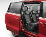 Interior de coches con puertas correderas rojas, mostrando asientos de cuero negro y detalles de costura.