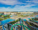 Wodne szaleństwo w Titanic Resort & Aquapark! Kolorowe zjeżdżalnie, baseny i palmy pod błękitnym niebem.