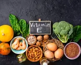 Assortiment d'aliments riches en vitamine E : courges, épinards, crevettes, noix, amandes, graines de tournesol, œufs, brocolis et sarrasin.