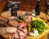 Idealne mięso na imprezę: grillowane kotlety, wędliny, ser, ogórki i papryka.