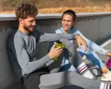 Ein Mann und eine Frau sitzen nach dem Sport und reden. Sie fragen sich, wie lange Pause nach Halbmarathon sinnvoll ist.