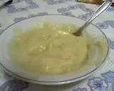 Un tazón blanco con un suave y cremoso puré de pescado, listo para ser disfrutado. Una cuchara plateada descansa en el tazón.