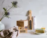 En stapel aleppotvål, en borste och en ansiktsrengöring. Trots att aleppotvål luktar illa, är den populär för sina naturliga ingredienser.