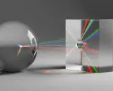 Światło rozszczepia się na pryzmacie, tworząc barwne smugi. To przykład, jak działa ray tracing.