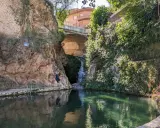 Un hombre posa junto a una cascada en un estanque natural en Ferez, Albacete.