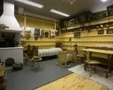 Wnętrze izby w muzeum w Szczawnicy: piec, łóżko, kołyska, stół i krzesła.