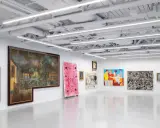 A vibrant art exhibition at Saatchi Yates, featuring diverse paintings and a sculpture, with a striking pink artwork and a figure in a colorful dress.