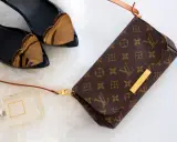 Torebka Louis Vuitton, czarne buty z sercami, perfumy na białym tle.
