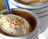 Zwei Becher mit cremigem Vanilleeis, bestreut mit bunten Streuseln. Ein köstliches Eiscafe Rezept für heiße Tage.