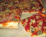 Pyszna pizza na cienkim cieście z pieczarkami i szynką, polana ketchupem. Idealna na szybki obiad.