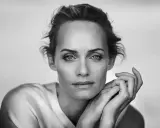 Ritratto in bianco e nero di una donna con mani appoggiate al viso, un'espressione intensa catturata da un fotografo ritrattista famoso.