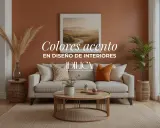 Sofá beige con cojines decorativos, uno de ellos naranja como **color acento**, en una sala de estar cálida.