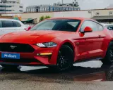 Un deportivo rojo, que es un coche coupe, brilla bajo la lluvia.