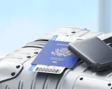 En powerbank, pass och flygbiljett ligger på en resväska, redo för resan med flygplan.