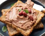 Pyszna pasta z czerwonej fasoli na chrupiących tostach, ozdobiona fasolkami i listkami ziół. Idealna na szybkie śniadanie.