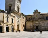 Piazza del Duomo a Lecce, un assaggio di cosa vedere a Lecce in un giorno: la cattedrale barocca e il campanile svettano sotto il sole.