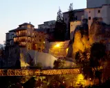 El puente de San Pablo en Cuenca, iluminado de noche, conecta las casas colgantes con la ciudad.