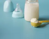 Biberon con latte, tettarella e misurino di latte in polvere, per capire quanto deve mangiare un neonato di 3 mesi.