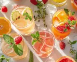 Cocktail gin jus de fruit, garni de fruits rouges et d'agrumes, prêt à rafraîchir.