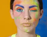 Rostro con maquillaje vibrante y purpurina. ¿Cómo quitar la purpurina de la cara? Este look es un desafío.
