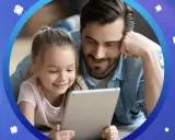 Ojciec i córka patrzą na tablet. Dowiedz się, jak zablokować internet w telefonie dziecka, by zapewnić mu bezpieczeństwo online.