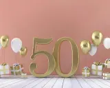 Złota liczba 50 otoczona balonami i prezentami. Idealne tło na życzenia na 50 urodziny.