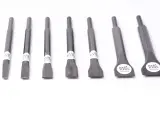 Un conjunto de cinceles de metal, cada uno con una punta afilada y un mango hexagonal, listos para trabajar la piedra.