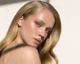 Delikatne rozjaśnianie brwi podkreśla naturalne piękno blondynki. Jej skóra lśni w słońcu.