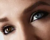 Oczy z heterochromią centralną: jedno niebieskie, drugie brązowe. Makijaż podkreśla ich niezwykły urok.