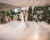 Brautpaar tanzt inmitten von Bodennebel und Funkenregen. Ein romantischer Moment, wie aus umgeschriebene Lieder zur Hochzeit.