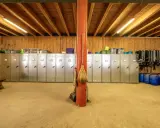 Reihe von Spinden, ideal zum Sattelschrank organisieren. Besen lehnen an rotem Pfosten.