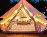 Tenda accogliente illuminata, perfetta per un'esperienza di glamping per famiglie. Letto comodo, tappeti e luci creano un'atmosfera magica.