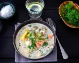 Krämig fisksoppa med lax och dill, en av många lyxiga fiskrecept. Serveras med citronvatten och havssalt.