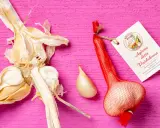 Aglione della Valdichiana, perfetto per le tue aglione ricette. Un bulbo intero e uno spicchio su sfondo rosa.
