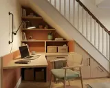 Aménagement bureau petit espace sous escalier. Bureau fonctionnel avec rangements intégrés, étagères et chaise confortable.