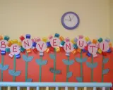 Fiori colorati con lettere formano la scritta "BENVENUTI", un'idea creativa per lavoretti di accoglienza.