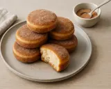 En hög med socker- och kaneldränkta krabbelurer, ett perfekt recept för fikat. En är uppäten, vilket visar det fluffiga inkråmet.