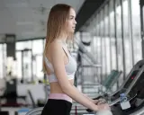 Junge Frau trainiert auf Laufband, vielleicht mit der 12-3-30 Methode.