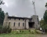 Kamienny budynek obserwatorium na szczycie góry, z kopułami teleskopów i wieżą telekomunikacyjną. To lubomirskie schronisko naukowców.