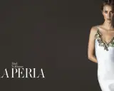 Model in a white slip dress with gold lace trim, with "LA PERLA" logo.