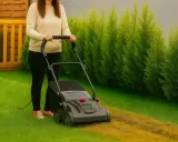 Kobieta używa rekultywatora, aby odświeżyć trawnik, usuwając starą trawę i mech.