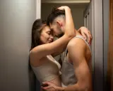 Para zbliża się do siebie, tworząc intymną scenę. Kobieta opiera się o ścianę, a mężczyzna obejmuje ją. Ich ciała są blisko siebie, sugerując pozycje seksualne na stojąco.