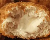 Un cordon bleu croustillant, coupé en deux, révèle un cœur fondant et crémeux.